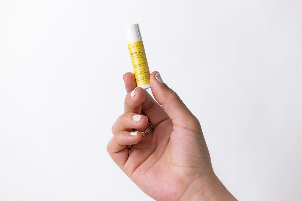 a hand holding a small tube