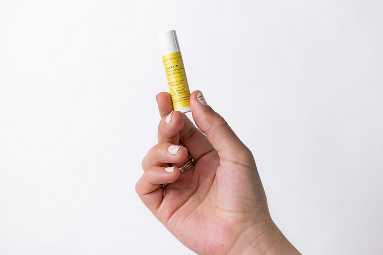 a hand holding a small tube