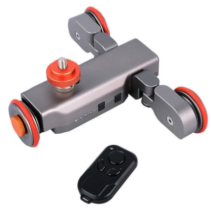 a grey device with red wheels and a remote