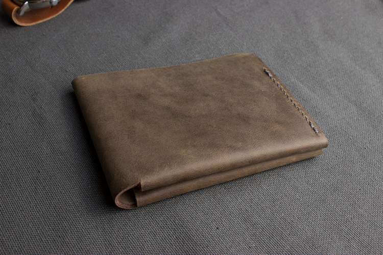 a brown wallet on a gray surface
