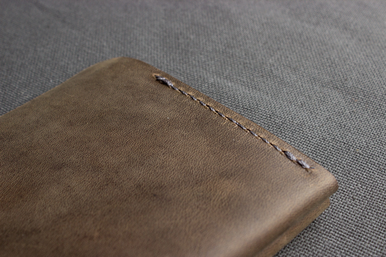 a brown leather wallet on a gray surface