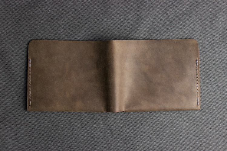 a brown leather wallet on a gray surface