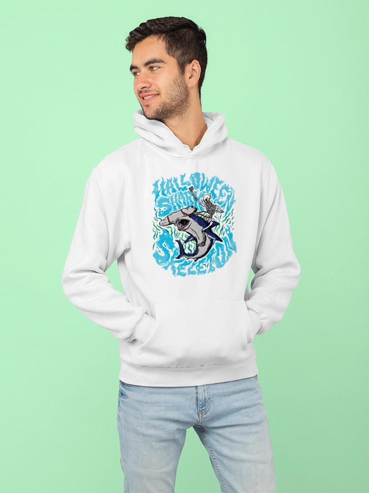 a man wearing a white sweatshirt with a cartoon shark on it