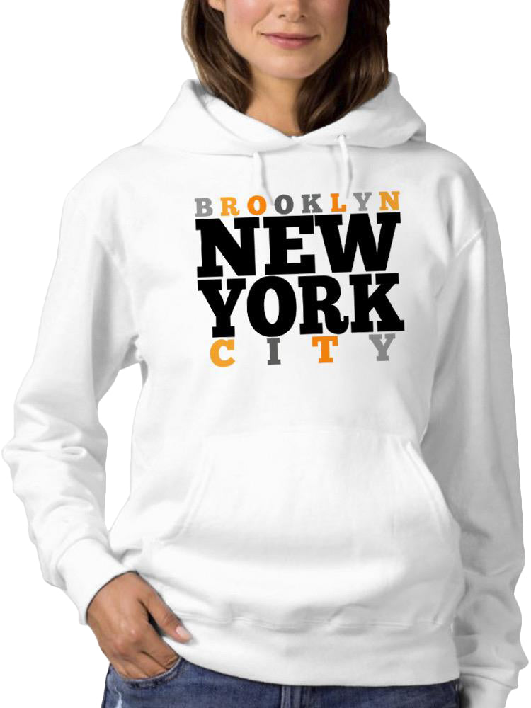 a woman wearing a white sweatshirt with black and orange text