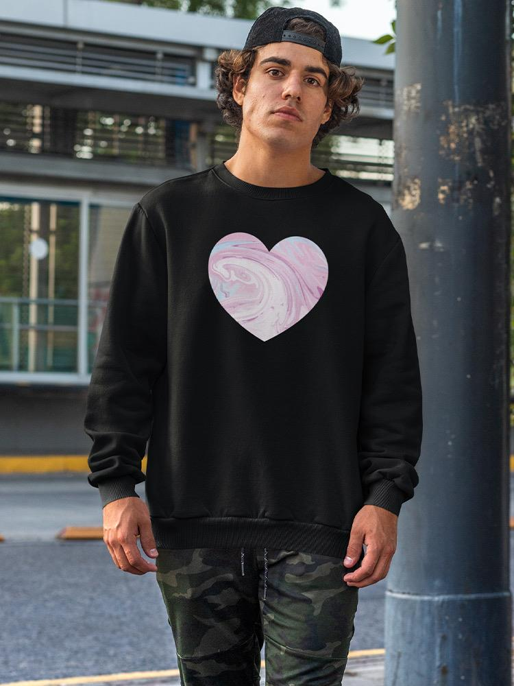 a man standing outside wearing a black sweatshirt with a heart on it