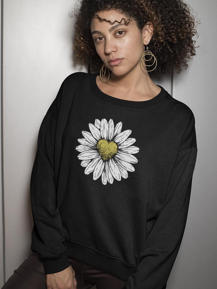 a woman with curly hair wearing a black sweatshirt with a flower on it