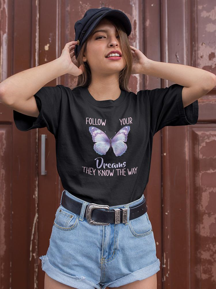 a woman wearing a black hat and a black shirt with a butterfly on it