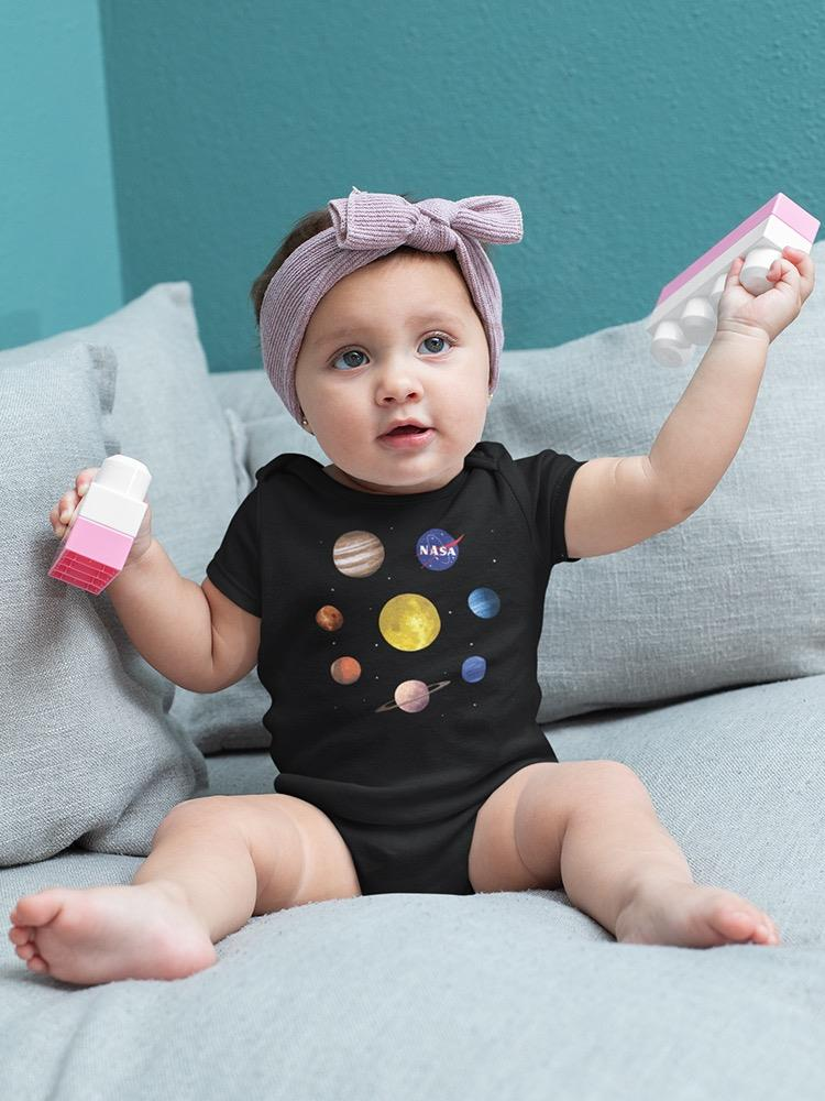 a baby with a purple headband holding a toy