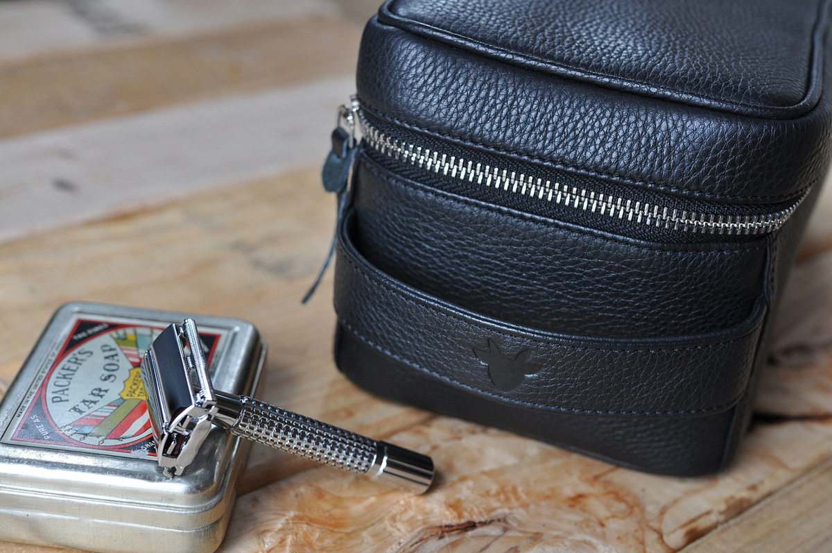 a black leather case with a silver handle and a razor
