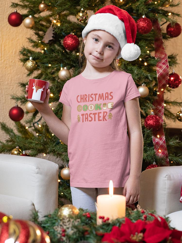a girl holding a mug in front of a christmas tree