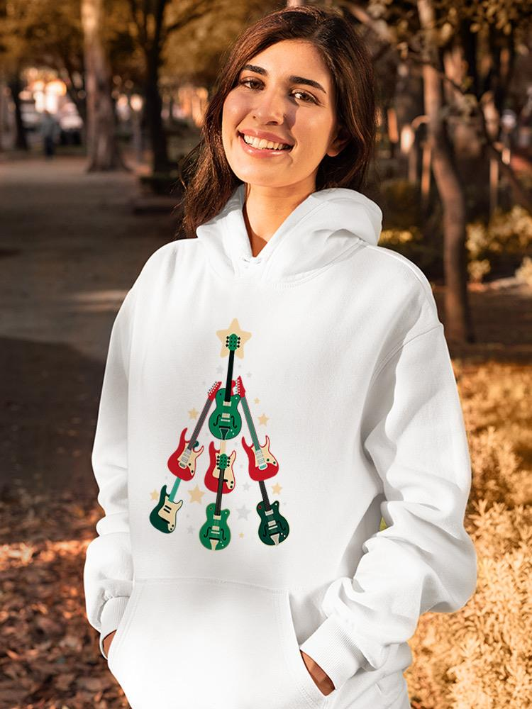 a woman smiling with a white sweatshirt with guitars on it