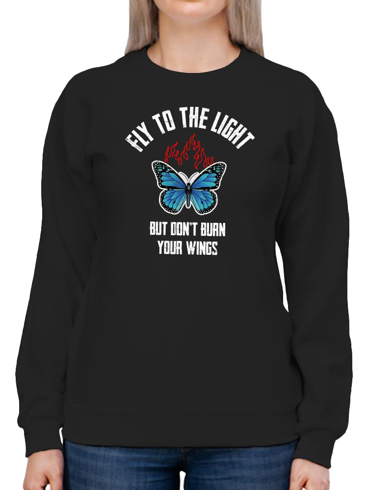 a person wearing a black sweatshirt with a blue butterfly and text