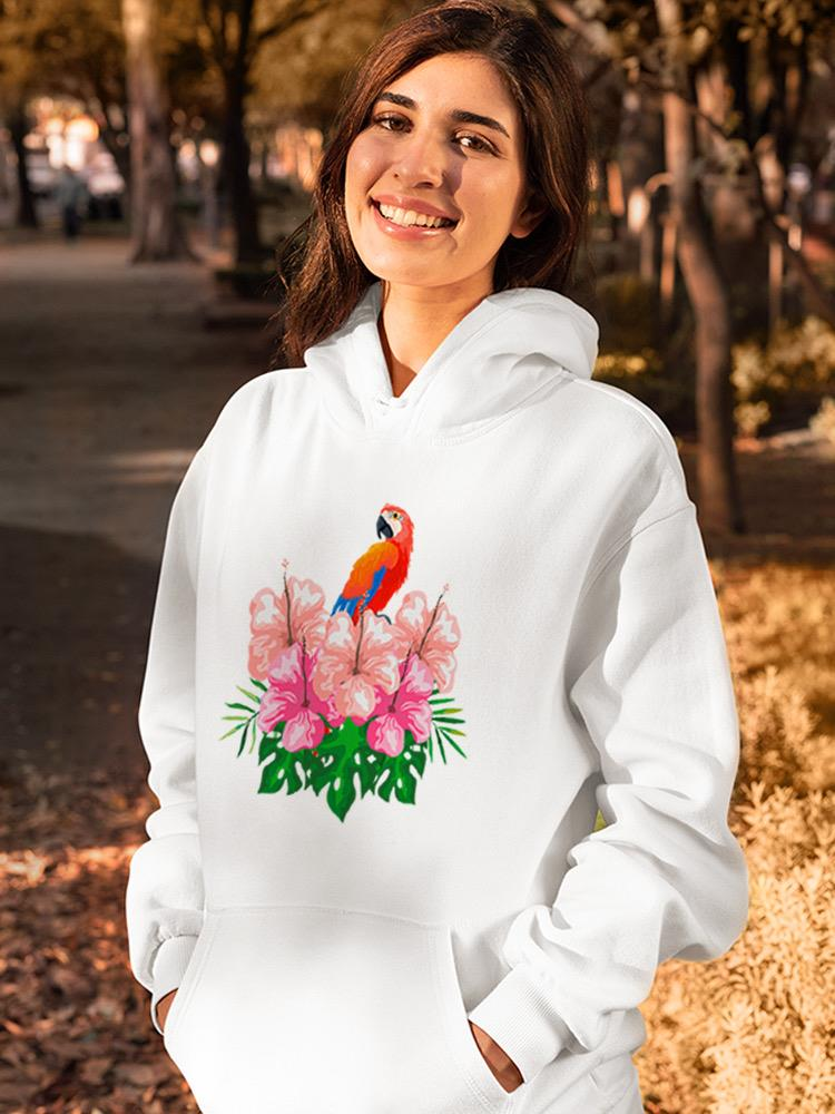 a woman smiling with a parrot on a white sweatshirt
