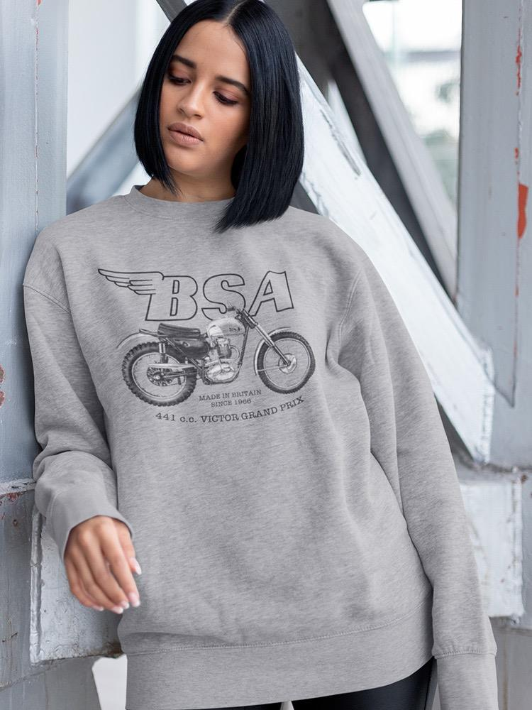 a woman with short black hair wearing a grey sweatshirt