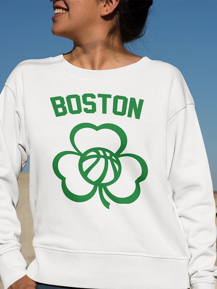 a woman wearing a white sweatshirt with a clover on it