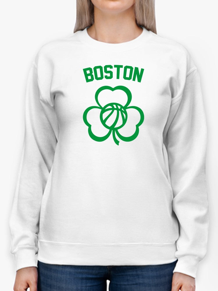 a person wearing a white sweatshirt with a green logo