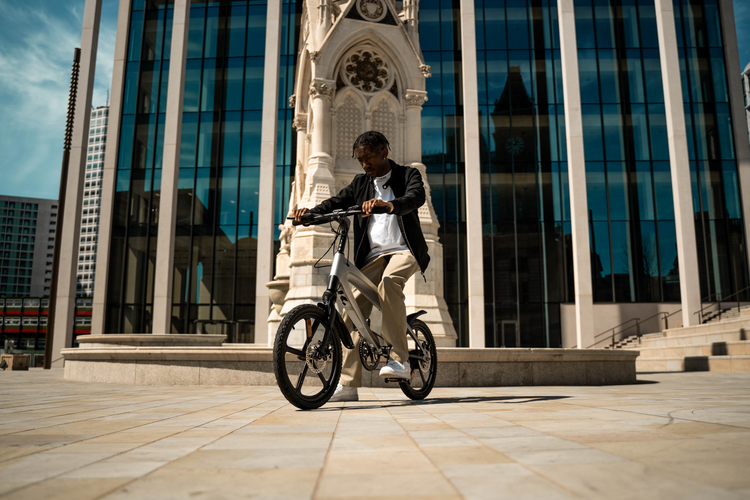 a man riding a bicycle in front of a tall building