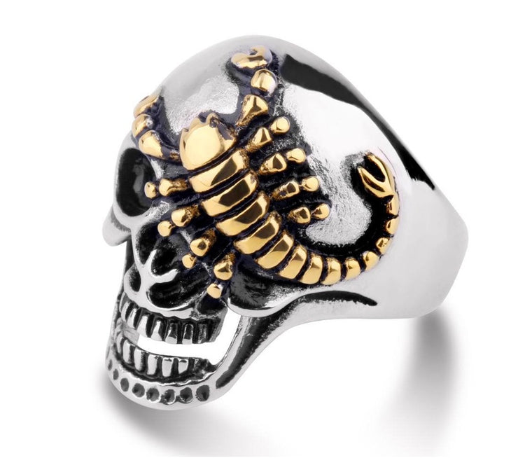 a silver and gold skull ring
