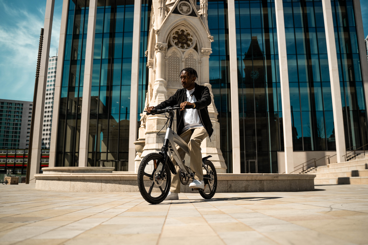 a man riding a bicycle in front of a tall building