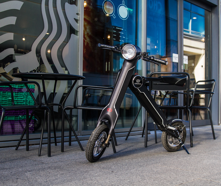 a black scooter parked outside a restaurant