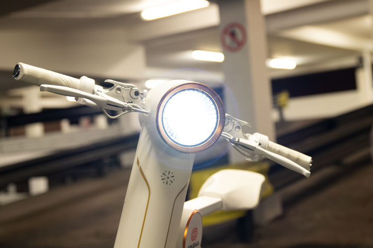 a white and gold motorcycle with a light on