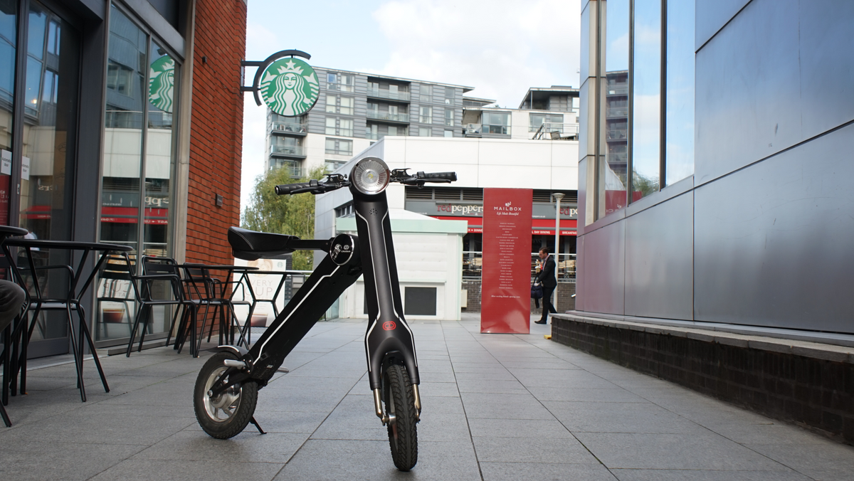 a black scooter on a sidewalk