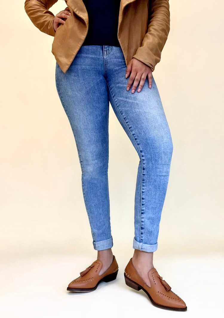 a woman wearing blue jeans and brown shoes