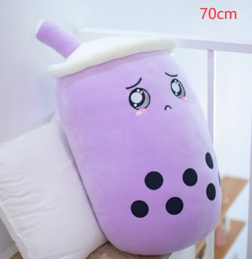 a purple soft toy with a sad face