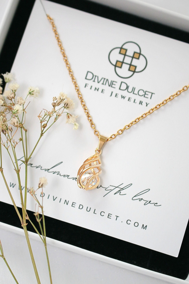 a gold necklace with a small flower on it