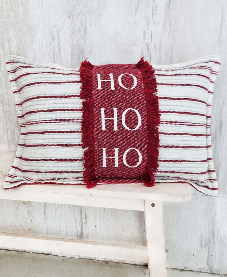 a red and white striped pillow with fringe