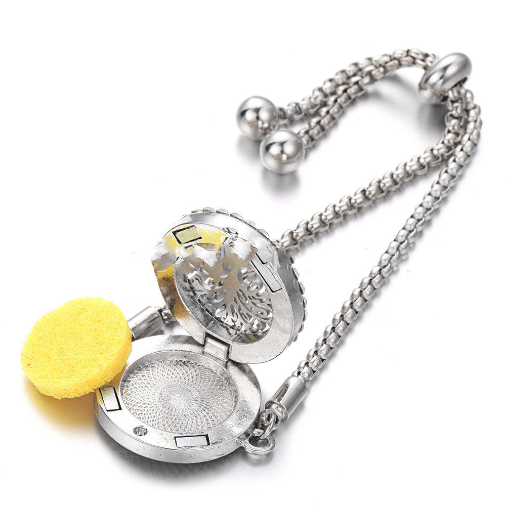 a silver locket with a yellow object on it