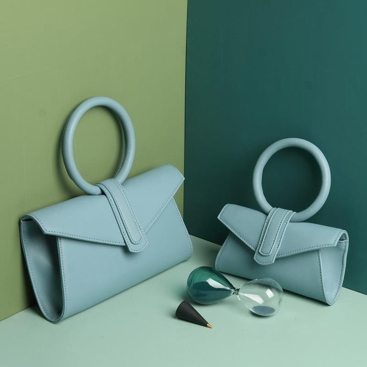 a pair of blue purses next to a hourglass