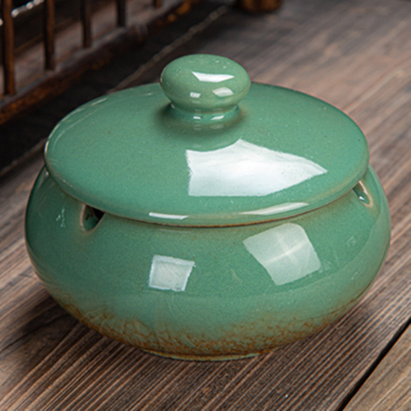 a green ceramic container with a lid