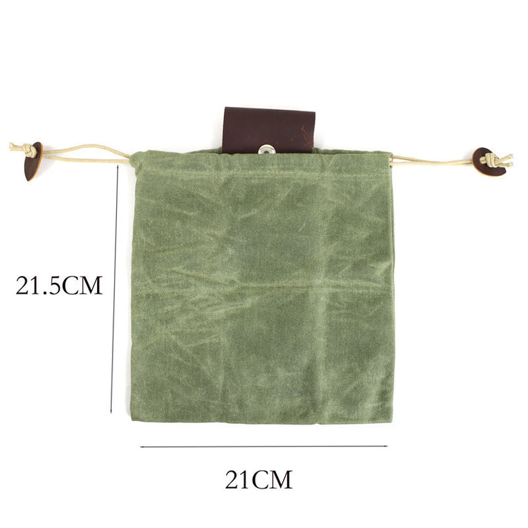 a small green bag with a brown string and a brown button
