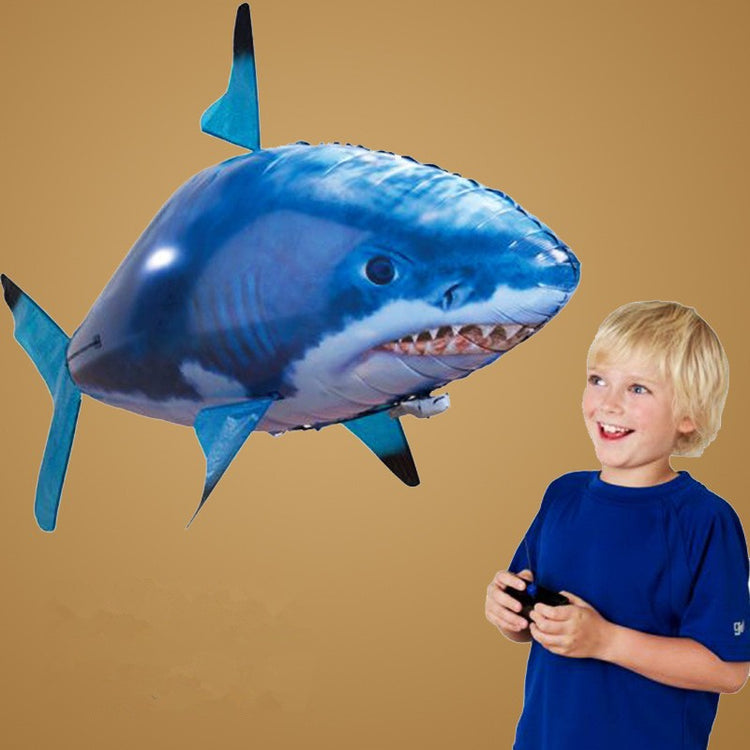 a boy looking at a balloon in the shape of a shark