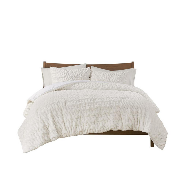 a bed with white comforter and pillows