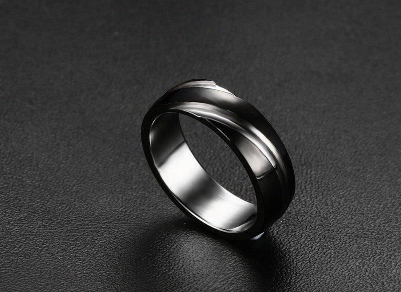 a silver ring on a black surface
