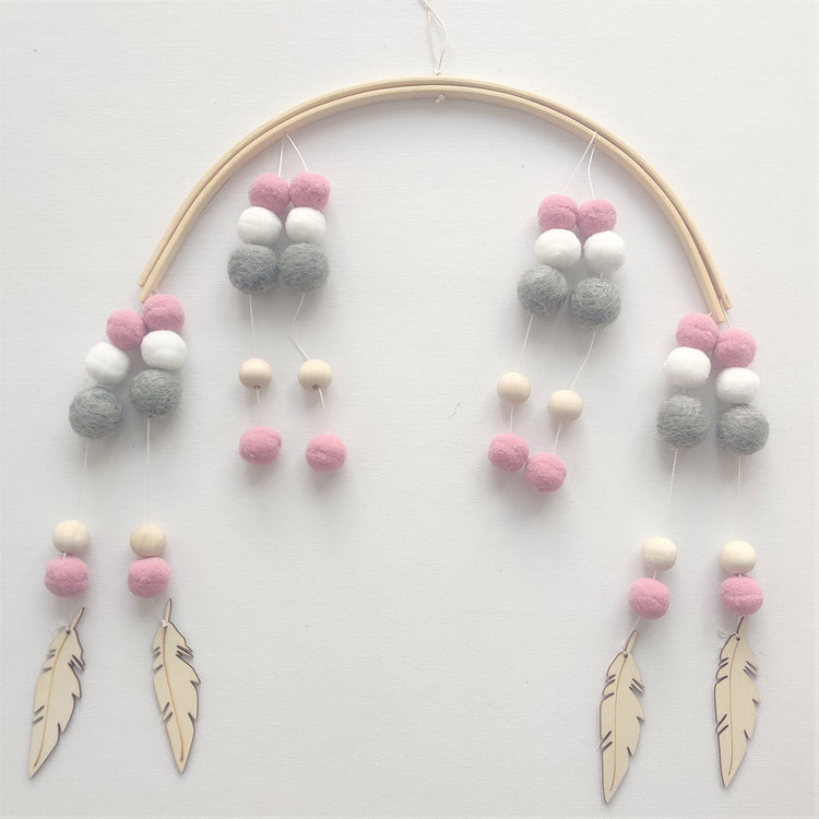 a mobile with feathers and beads