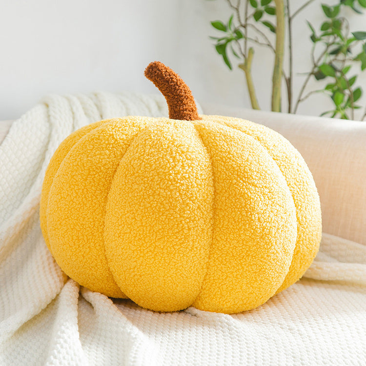 a yellow pumpkin on a white blanket