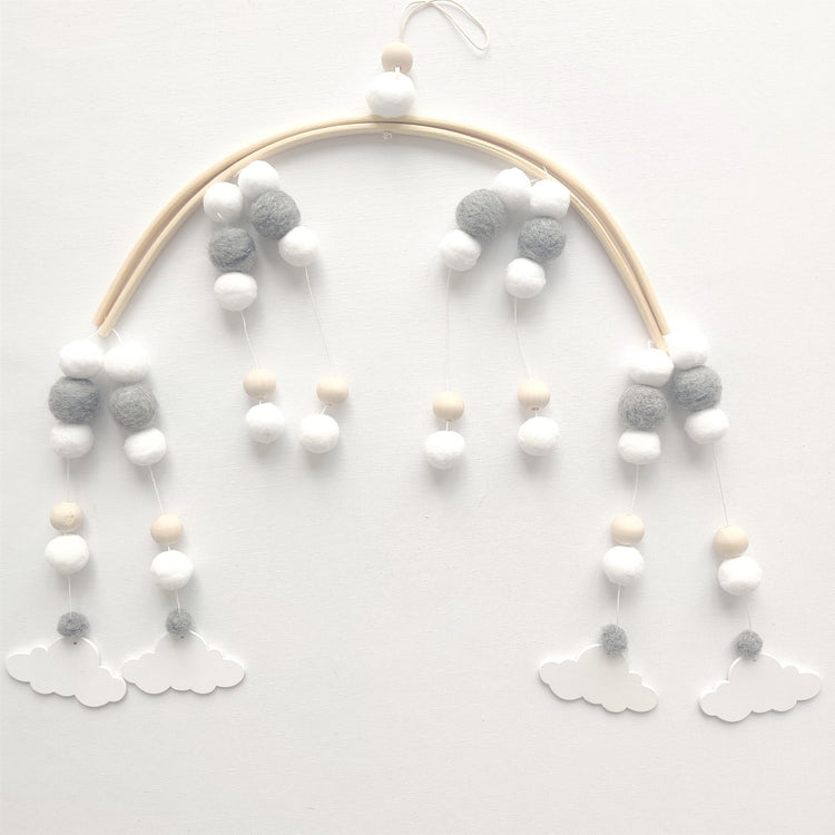 a mobile with pom poms and clouds