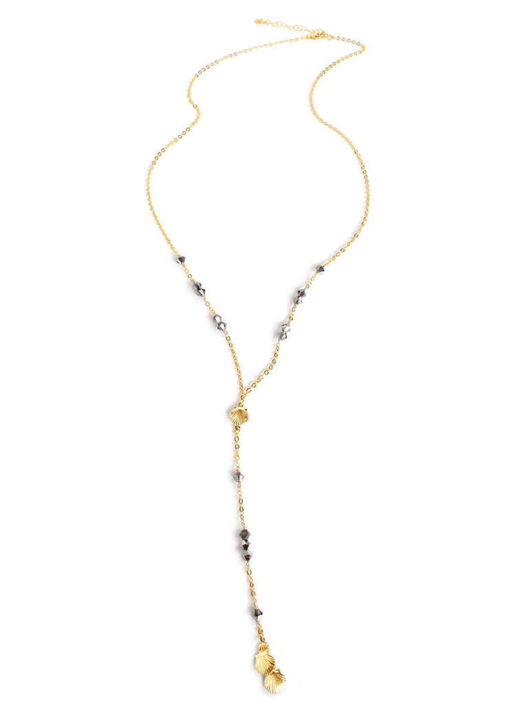 a gold necklace with a cross and a small stone pendant