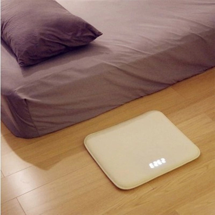 a white square object on the floor next to a bed