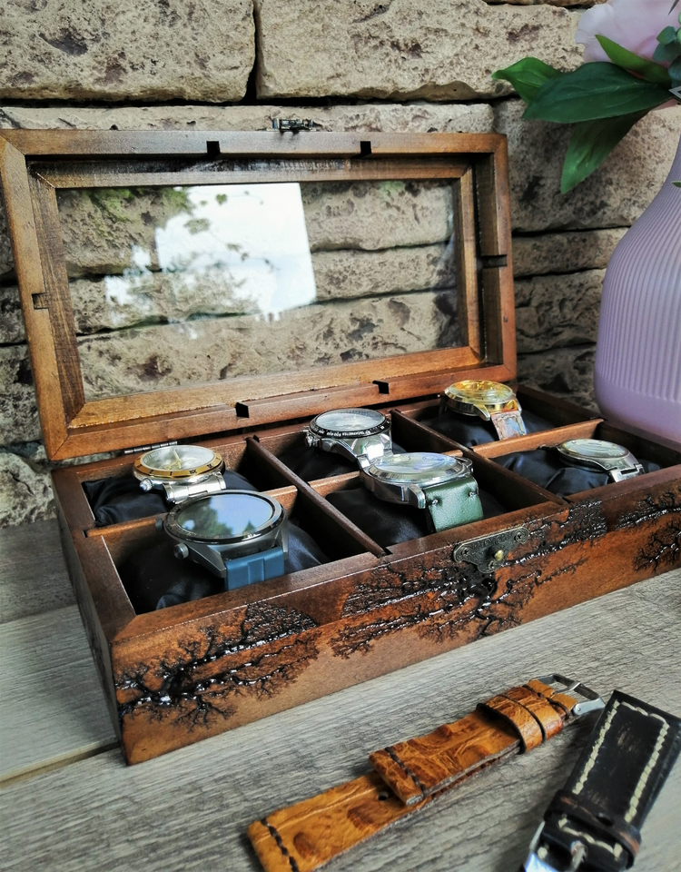a wooden box with several watches in it