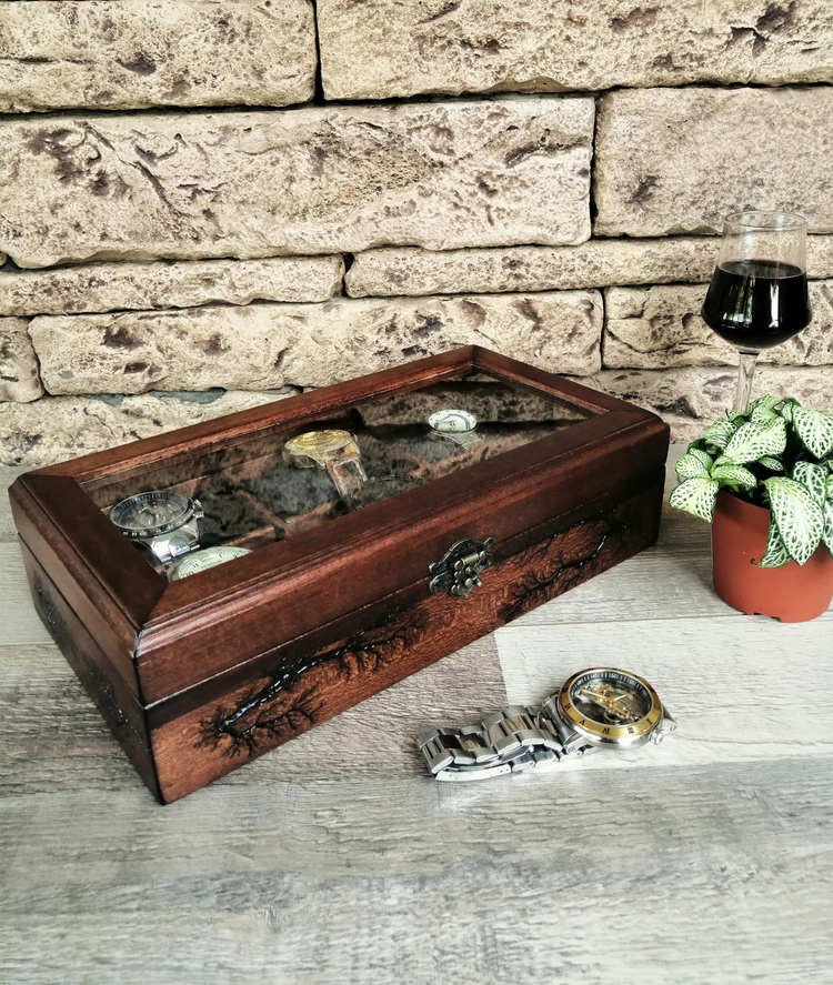a wooden box with a glass and a watch on a wood surface