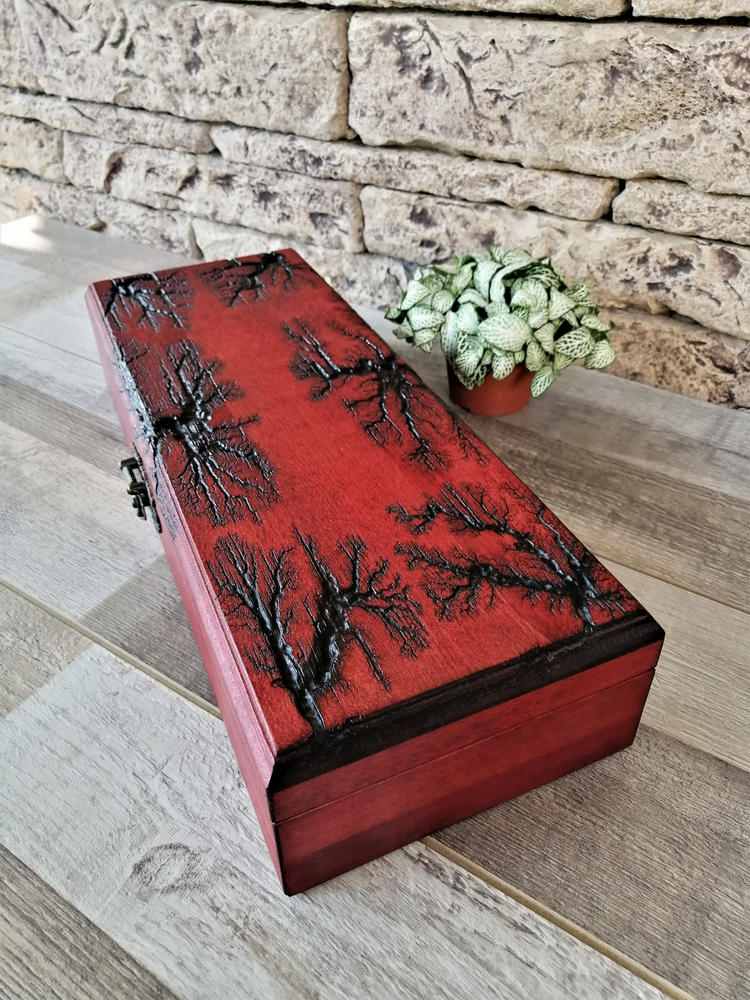 a red box with a tree design on it next to a plant