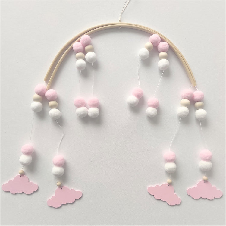 a mobile with pink and white balls and clouds