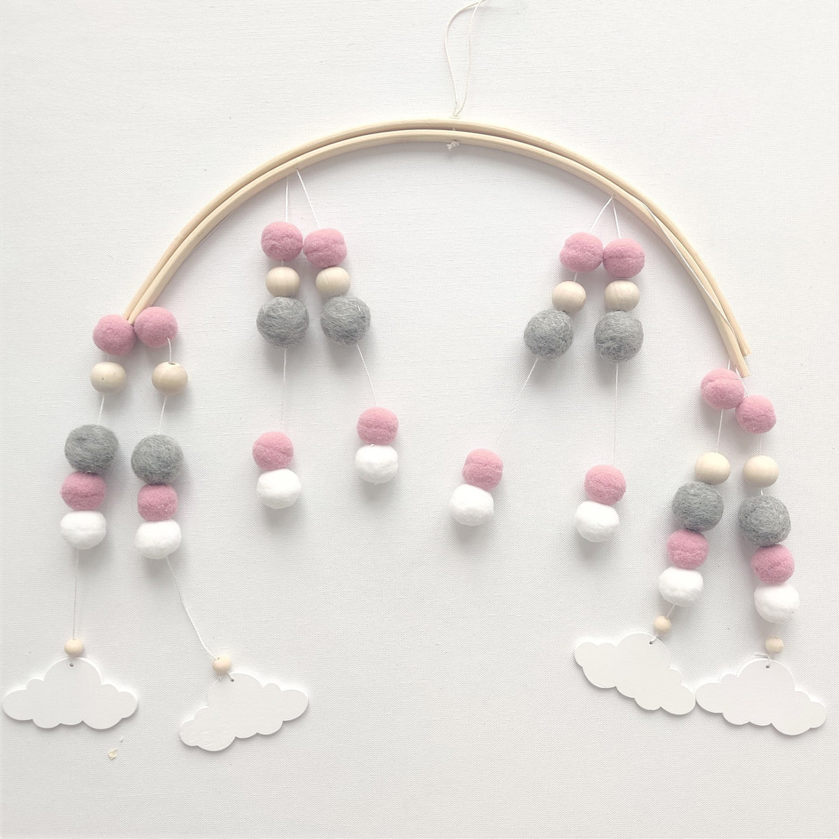 a mobile with balls and clouds on a white surface