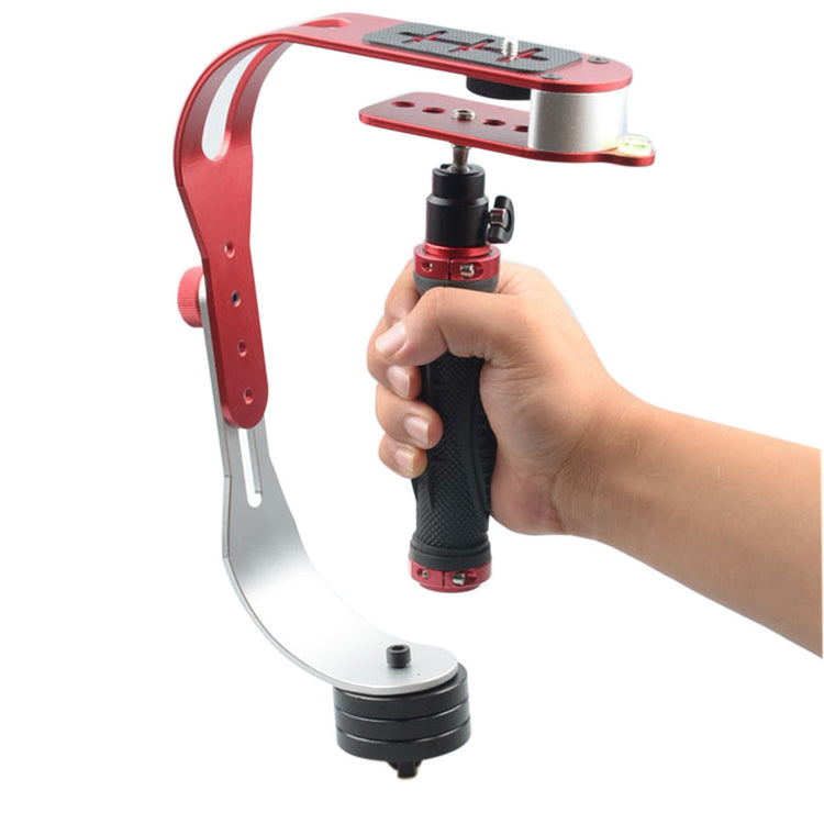 a hand holding a red and silver camera stabilizer