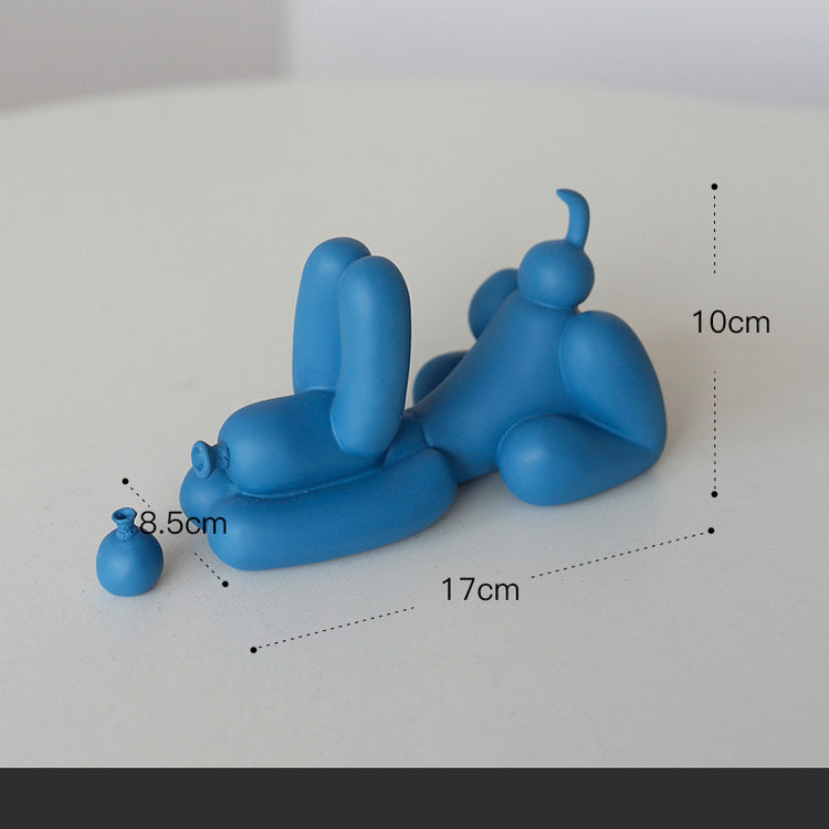 a blue figurine of a person lying on a white surface