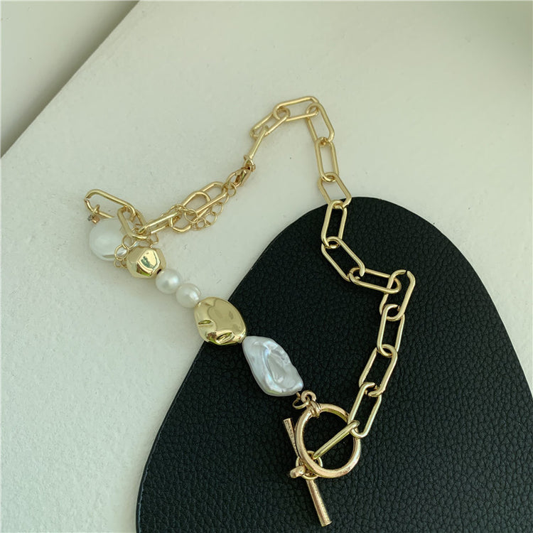 a gold chain with a gold and white bead on it